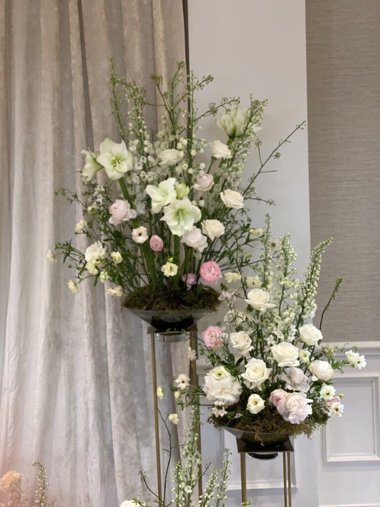 Elegant blush and white wedding centerpiece with roses and garden flowers on a reception table
