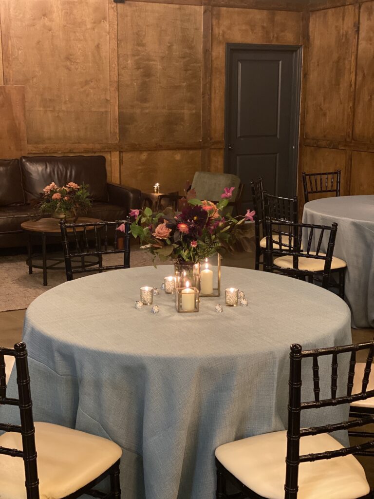 Delicate pink roses and blue forget-me-nots in a small glass bud vase for a wedding place setting