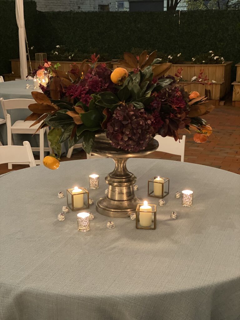 Single pink peony bloom in a small gold vessel as a wedding table accent