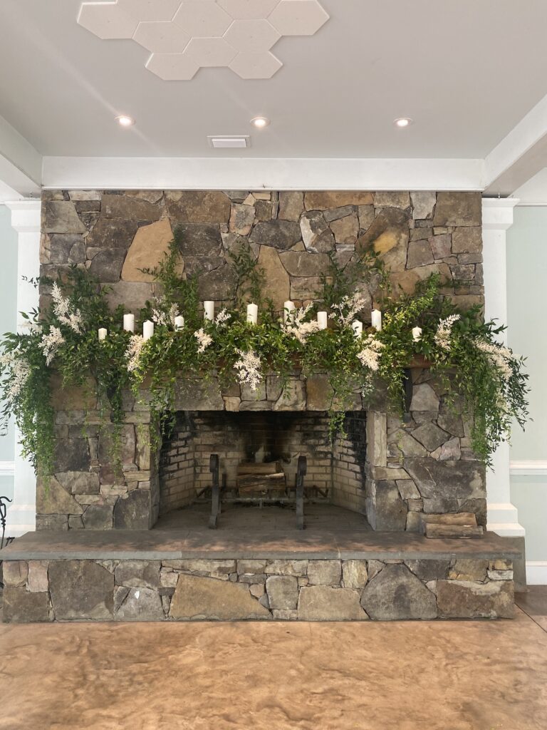 Indoor ceremony space with hanging floral installation of greenery and white blooms