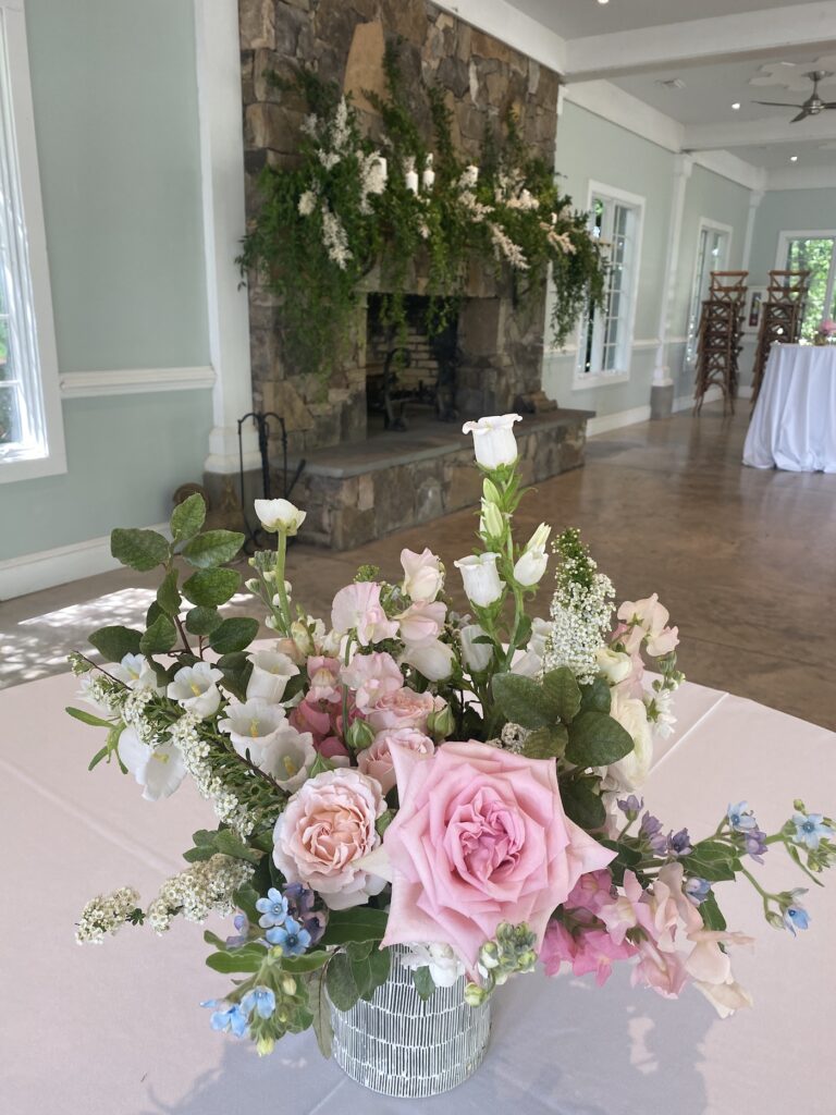 Bridesmaid holding a soft pastel bouquet of pink roses and lavender blooms at a garden wedding