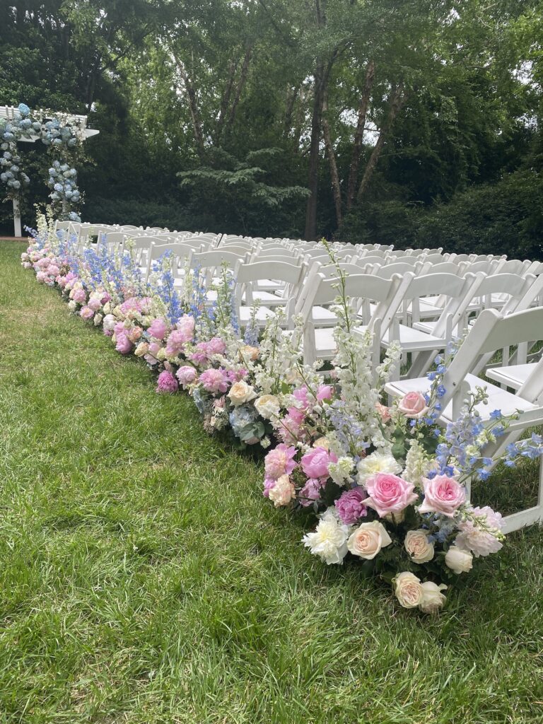Wedding ceremony with cascading floral garlands and white garden roses at a stone fireplace