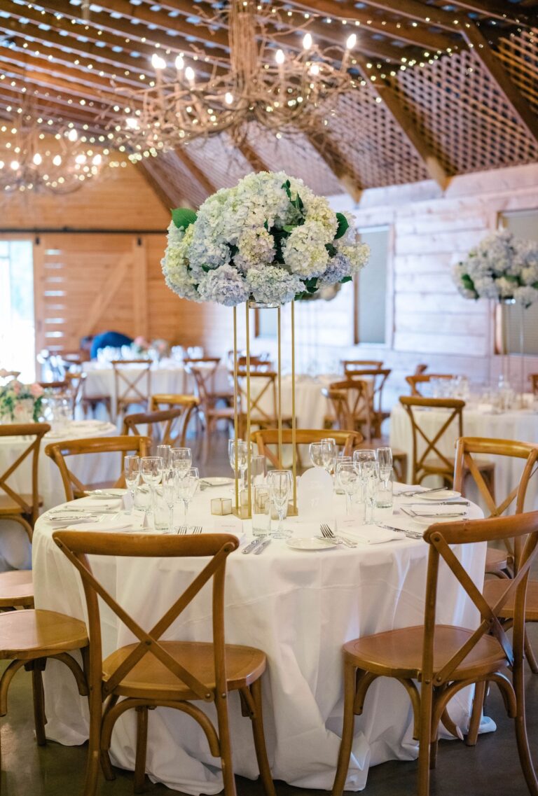Bride and groom at a lush outdoor ceremony with cascading floral arch of pink and white garden roses