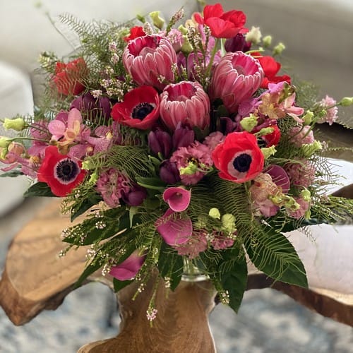 Colorful spring floral arrangement with anemones tulips and ranunculus - order Mother's Day flowers early