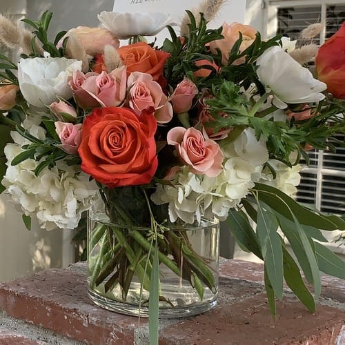 Romantic blush and ivory arrangement with soft roses and trailing greenery inspired by 2026 wedding flower trends in Raleigh - wedding flower trends 2026