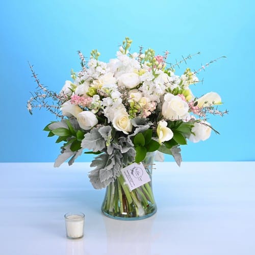 White and ivory roses with lush trailing greenery in an elegant wedding style arrangement by a Raleigh NC wedding florist - choosing a wedding florist