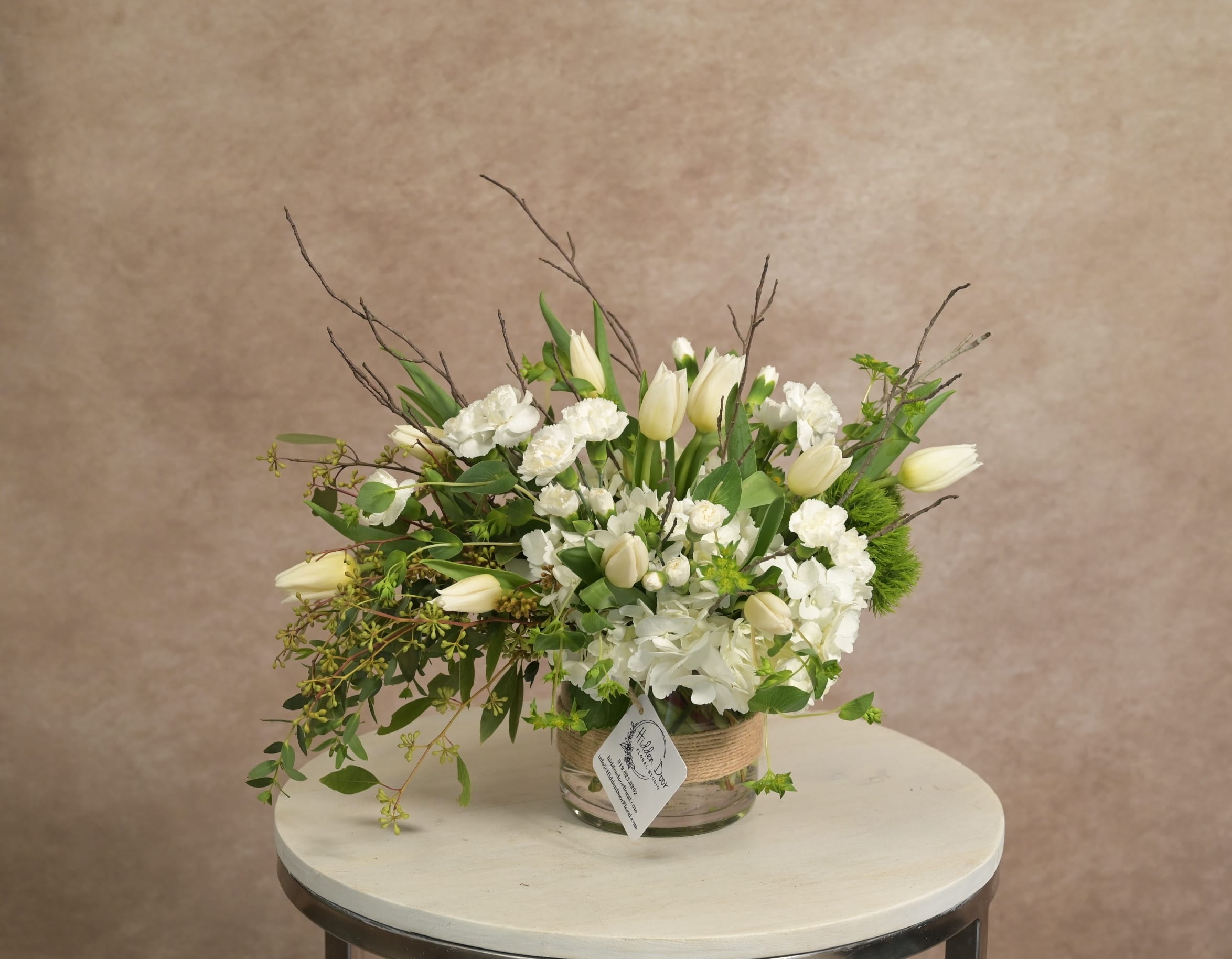 Soft white and blush arrangement with garden roses, hydrangea, lisianthus and trailing greenery by Hidden Door Floral Studio